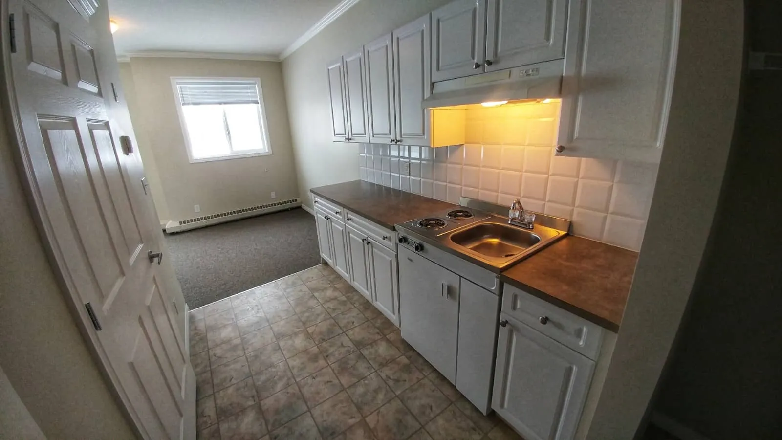 Suite kitchenette with white cabinets, a two-burner range and a sink